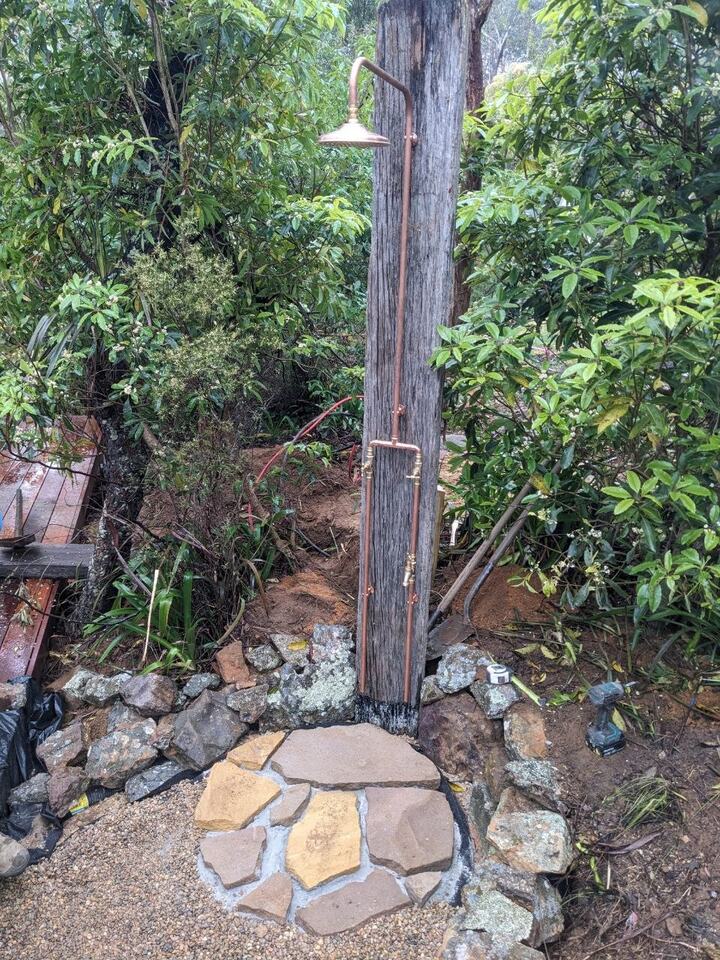 Exposed copper outdoor shower with rainhead