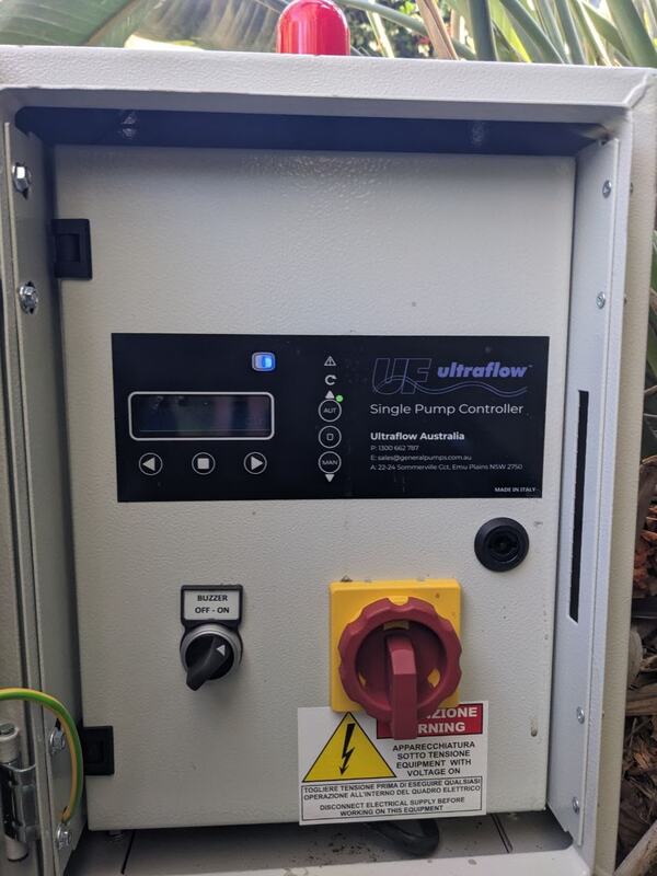 An open pump control cabinet containing an Ultraflow single pump controller with a digital display, an AUT/MAN mode selector with its indicator lights, a buzzer switch and a yellow and red main isolator